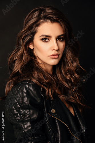 Fotografie beautiful sexy woman in elegant leather jacket posing in studio