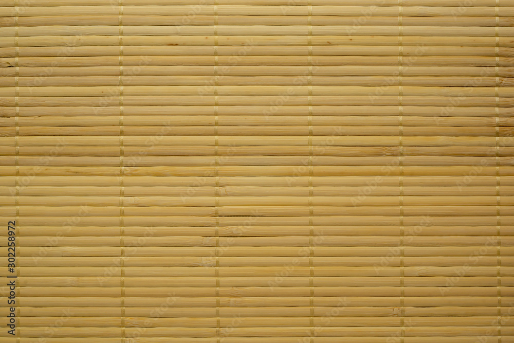 Mat of thin yellow bamboo sticks textured background Mat of thin yellow bamboo sticks textured background