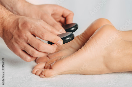 female feets while procedure hot stone massage  close up