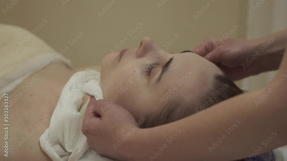 CU Relaxed woman receiving face massage. Young woman came in spa center for anti-agin or face lifting massage CU Relaxed woman receiving face massage. Young woman came in spa center for anti-agin or face lifting massage