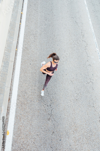 Beautiful woman running in the road. Fitness, workout, sport, lifestyle concept.