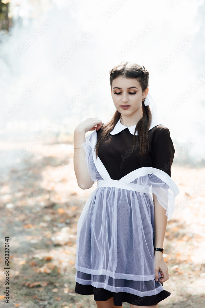 The young beautiful girl. Girl wearing in a school uniform. Outdoor photo of beautiful girl with long hair and perfect makeup. Outdoor fashion portrait of glamour lady. The young beautiful girl. Girl wearing in a school uniform. Outdoor photo of beautiful girl with long hair and perfect makeup. Outdoor fashion portrait of glamour lady.