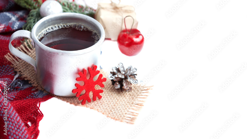 Hot christmas beverage black tea in mug with new year decorations, Cone, present, silver ball, apple, plaid on white background. Winter time top view. Christmas mood Hot christmas beverage black tea in mug with new year decorations, Cone, present, silver ball, apple, plaid on white background. Winter time top view. Christmas mood