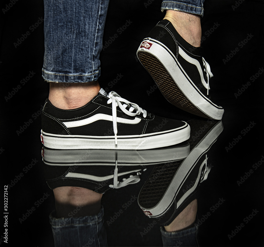 Young man wearing brand new black and white Vans Old Skool shoes Stock  Photo | Adobe Stock