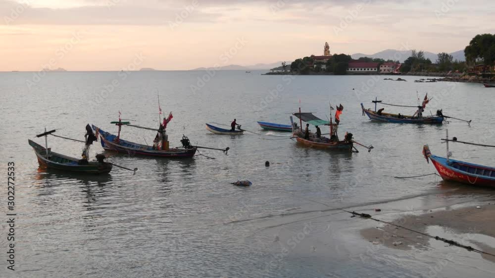Big Buddha temple surrounded by calm water and old Muslim fishing longtail boats on seaside of Samui paradise tropical exotic island, Thailand. Peaceful coexistence of cultures and religions Big Buddha temple surrounded by calm water and old Muslim fishing longtail boats on seaside of Samui paradise tropical exotic island, Thailand. Peaceful coexistence of cultures and religions