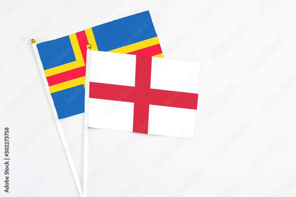 England and Aland Islands stick flags on white background. High quality fabric, miniature national flag. Peaceful global concept.White floor for copy space.