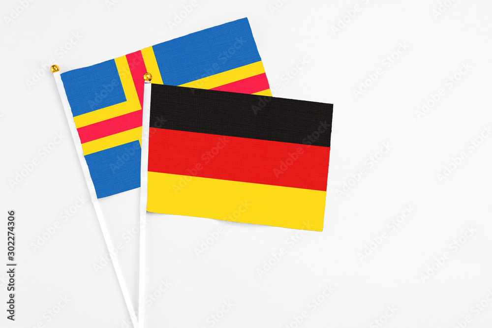 Germany and Aland Islands stick flags on white background. High quality fabric, miniature national flag. Peaceful global concept.White floor for copy space.