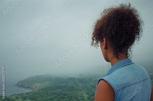 Black woman looking at the horizon in the Andrín Beach from the Boriza viewpoint. Llanes, Asturies, Spain photo