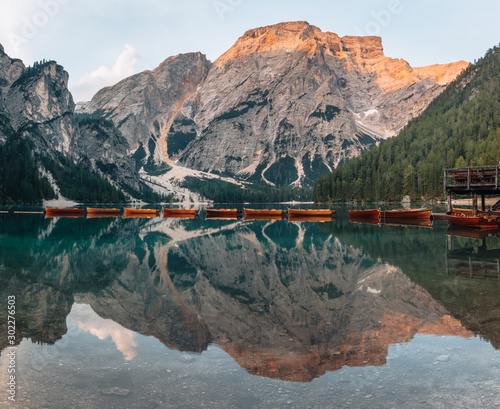 Morning at Lago di Braies with reflection on calm water, mouintain with lightrays on the background, Dolomites, Italy.