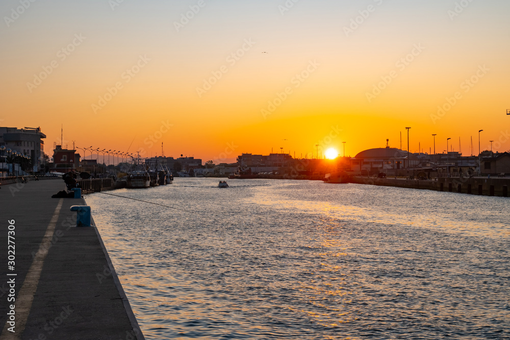 Little boat for fishing in Fiumicino port at sunrise.