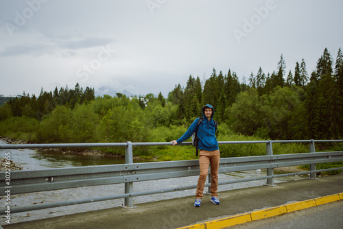 male tourist standing beside the mountain river