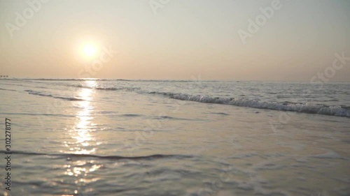 Calm waves of Mediterranean Sea rolling to the sandy beach at sunset. Beautiful sunrise in Turkey. Perfect calming water. photo