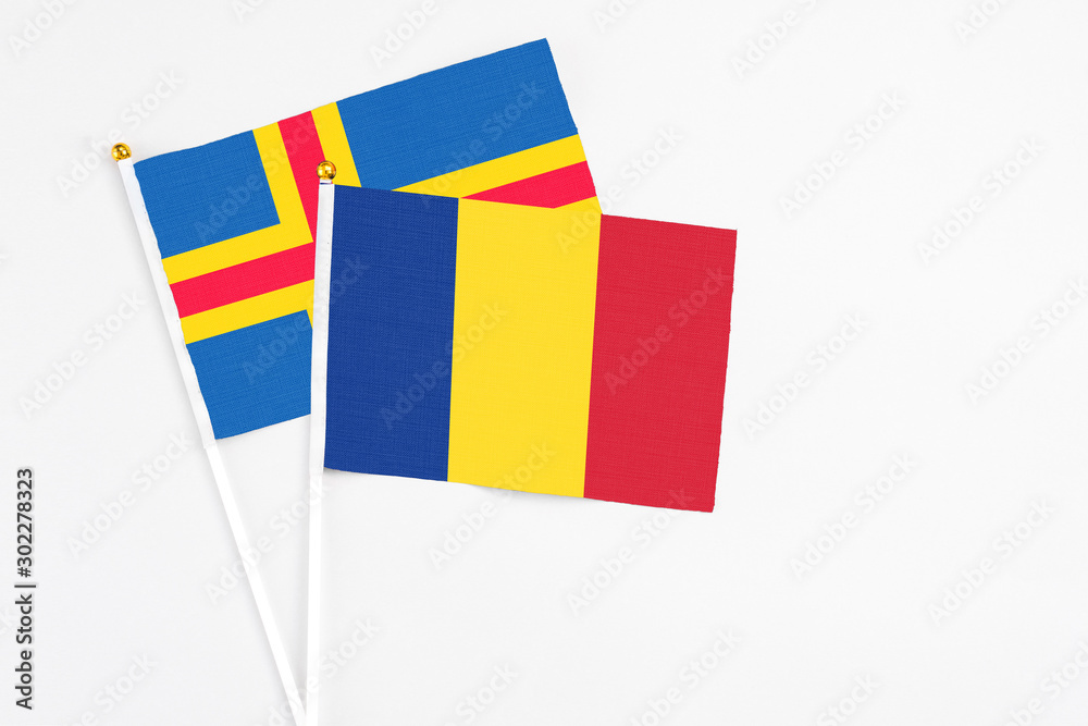Romania and Aland Islands stick flags on white background. High quality fabric, miniature national flag. Peaceful global concept.White floor for copy space. Romania and Aland Islands stick flags on white background. High quality fabric, miniature national flag. Peaceful global concept.White floor for copy space.