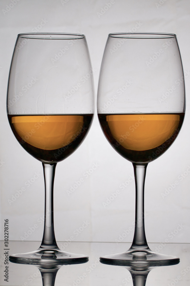 Wine glass goblets on a long leg. They stand nearby. They have a small amount of alcohol. Wine glass goblets on a long leg. They stand nearby. They have a small amount of alcohol.