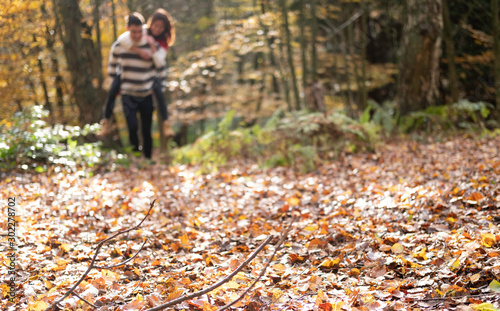 Couple piggyback in the woods