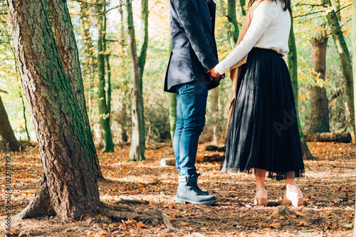 Couple holding hands in the woods