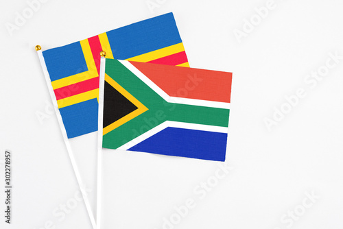 South Africa and Aland Islands stick flags on white background. High quality fabric  miniature national flag. Peaceful global concept.White floor for copy space.