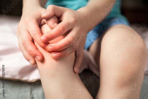 pain in the knee joints of the child. the boy's knees hurt