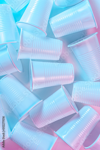Disposable plastic cups on a light background in pastel colors. Minimalistic ecologically clean still life. Pop Art. And ecology problem concept.
