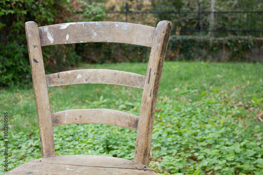 Close-up on a Workshop Chair Back Against a Grassy Background Close-up on a Workshop Chair Back Against a Grassy Background