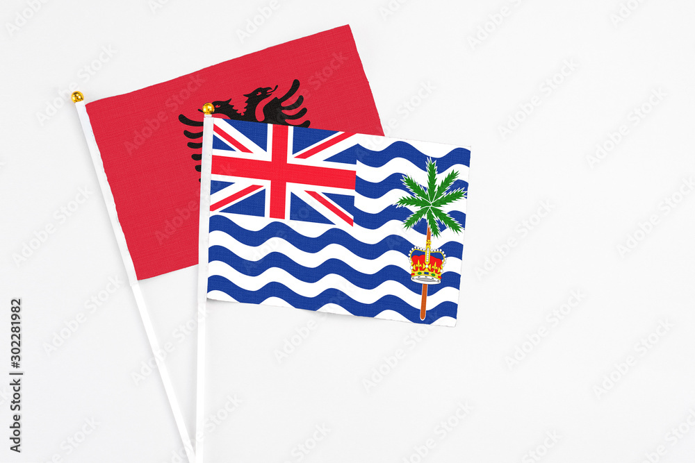 Fototapeta premium British Indian Ocean Territory and Albania stick flags on white background. High quality fabric, miniature national flag. Peaceful global concept.White floor for copy space.