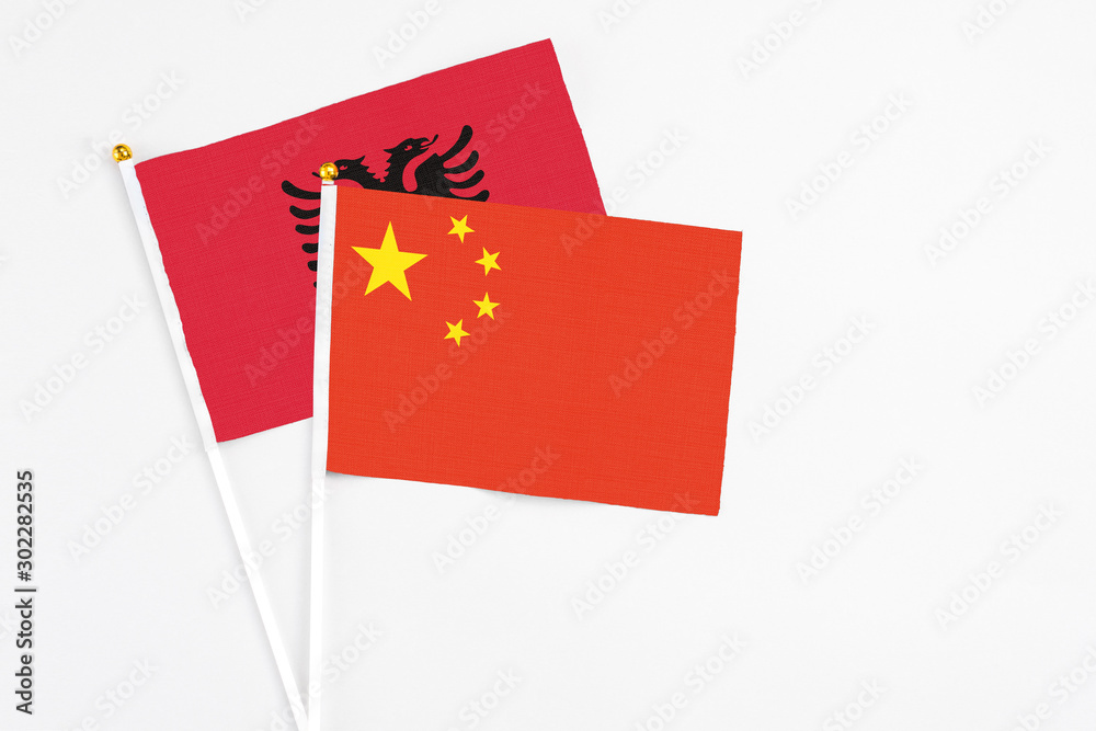 China and Albania stick flags on white background. High quality fabric, miniature national flag. Peaceful global concept.White floor for copy space. China and Albania stick flags on white background. High quality fabric, miniature national flag. Peaceful global concept.White floor for copy space.