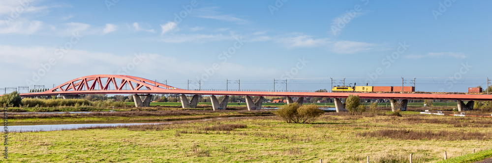 Scenic view Red railroad bridge Hanzeboog over the IJssel river at the entrance of Zwolle in the Netherlands