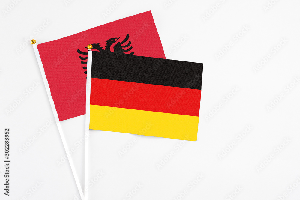 Germany and Albania stick flags on white background. High quality fabric, miniature national flag. Peaceful global concept.White floor for copy space. Germany and Albania stick flags on white background. High quality fabric, miniature national flag. Peaceful global concept.White floor for copy space.