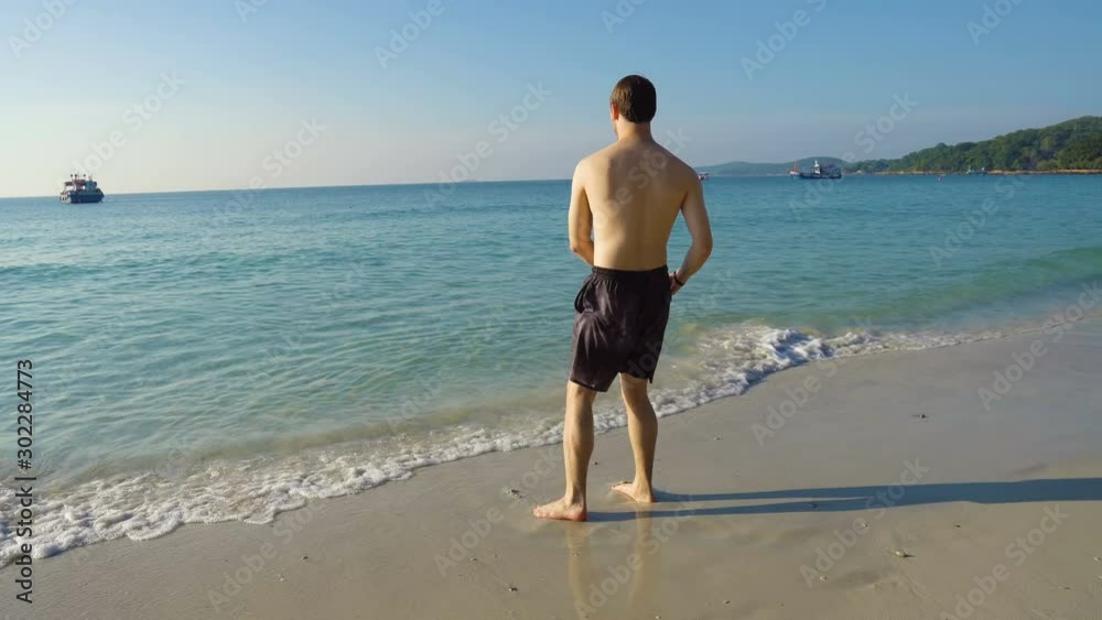 Man Skipping Stones into Ocean on Tropical Island Beach Man Skipping Stones into Ocean on Tropical Island Beach