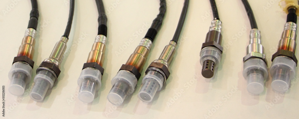 New lambda sensors on white background, car injector engine exhaust emission control repair