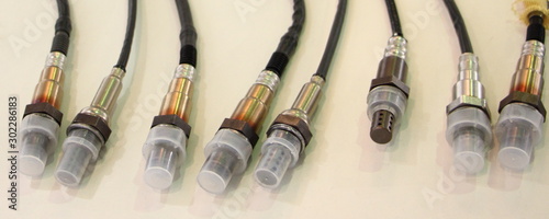 New lambda sensors on white background, car injector engine exhaust emission control repair