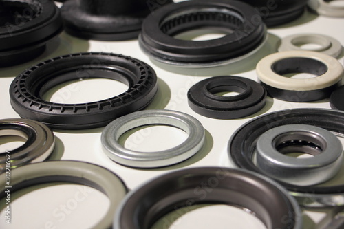 A many new o-rings and bearings on white table, car parts background texture
