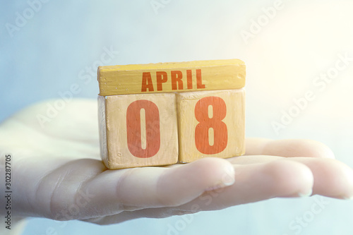 april 8th. Day 8 of month,Handmade wood cube with date month and day on female palm spring month, day of the year concept