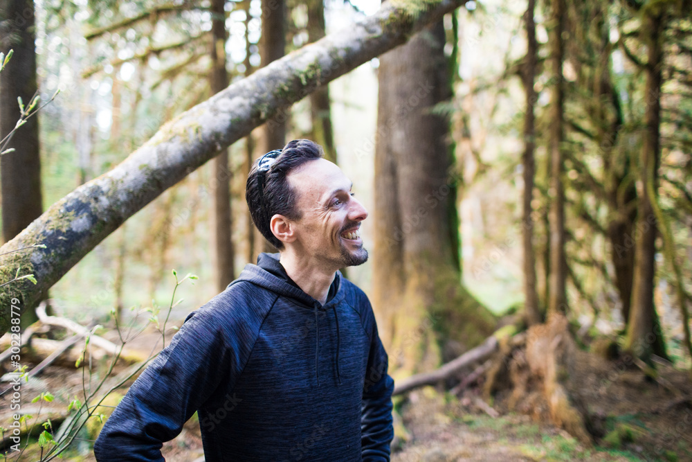 Portrait of man wearing sweater smiling in the forest. Portrait of man wearing sweater smiling in the forest.