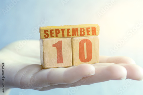 september 10th. Day 10 of month,Handmade wood cube with date month and day on female palm autumn month, day of the year concept