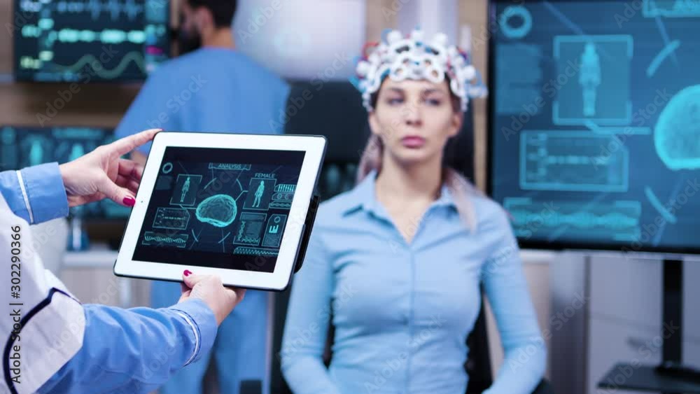 Female doctor looking at tablet with patient brain activty