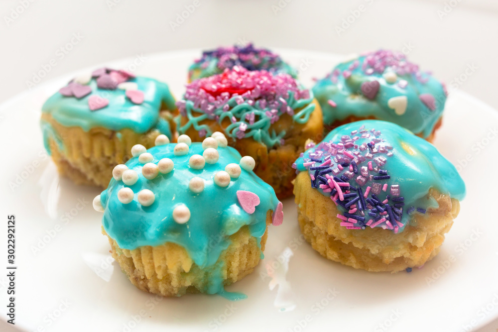 Homemade cupcakes with colorful icing on a plate Homemade cupcakes with colorful icing on a plate