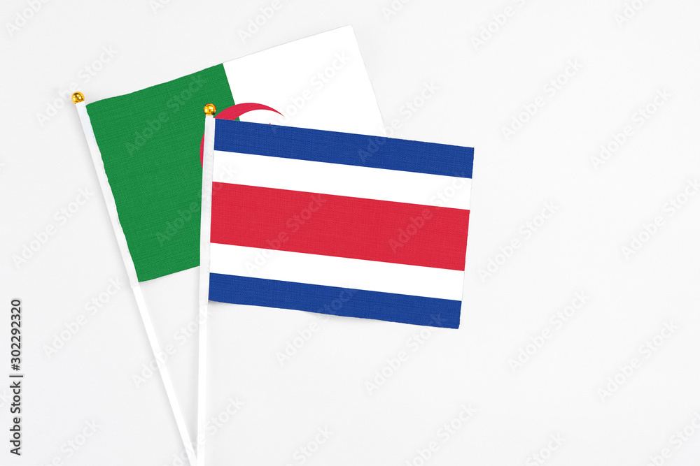 Costa Rica and Algeria stick flags on white background. High quality fabric, miniature national flag. Peaceful global concept.White floor for copy space. Costa Rica and Algeria stick flags on white background. High quality fabric, miniature national flag. Peaceful global concept.White floor for copy space.
