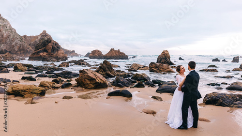 rocky seashore and high cliffs. gloomy day. the groom admires th