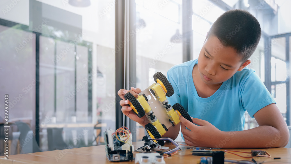 Concentrated boy creating robot at lab. Concentrated boy creating robot at lab.