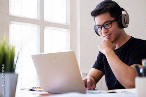 Young man student study at home using laptop and learning online photo