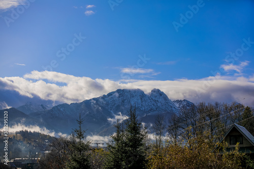 HDR photo of the Tatra Mountains and Great Giewont Peak with the steel Cross between clouds.