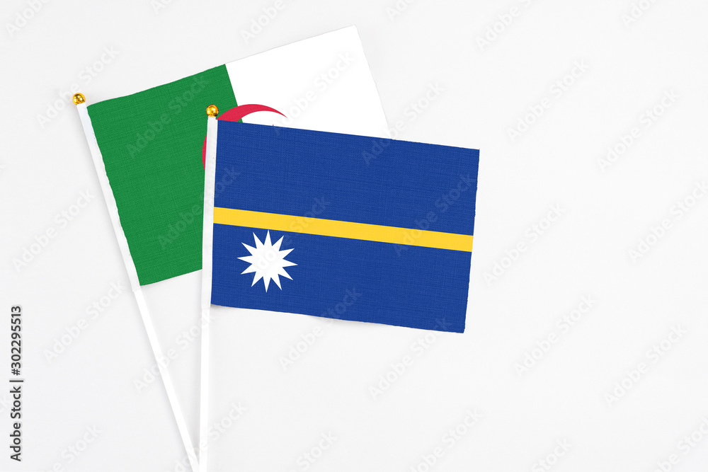 Nauru and Algeria stick flags on white background. High quality fabric, miniature national flag. Peaceful global concept.White floor for copy space. Nauru and Algeria stick flags on white background. High quality fabric, miniature national flag. Peaceful global concept.White floor for copy space.