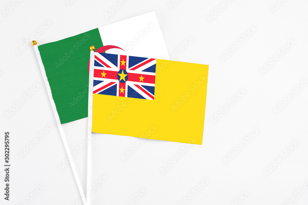 Niue and Algeria stick flags on white background. High quality fabric, miniature national flag. Peaceful global concept.White floor for copy space. Niue and Algeria stick flags on white background. High quality fabric, miniature national flag. Peaceful global concept.White floor for copy space.