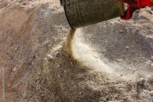 Loading sand with a shovel into a bucket