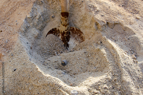 Loading sand with a shovel into a bucket