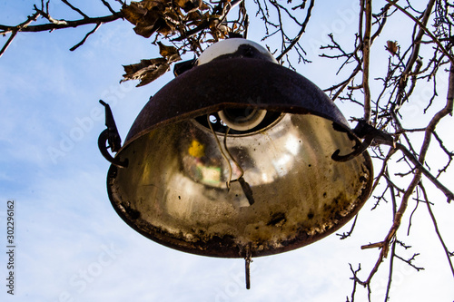 Old, rusty lantern hanging on a sky background