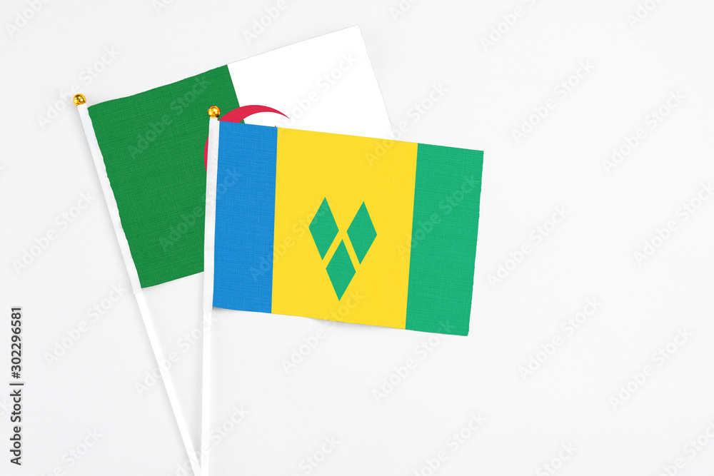 Saint Vincent And The Grenadines and Algeria stick flags on white background. High quality fabric, miniature national flag. Peaceful global concept.White floor for copy space. Saint Vincent And The Grenadines and Algeria stick flags on white background. High quality fabric, miniature national flag. Peaceful global concept.White floor for copy space.