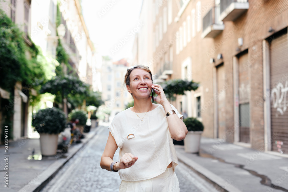 Smilling woman using smartphone in the city, Rome, Italy