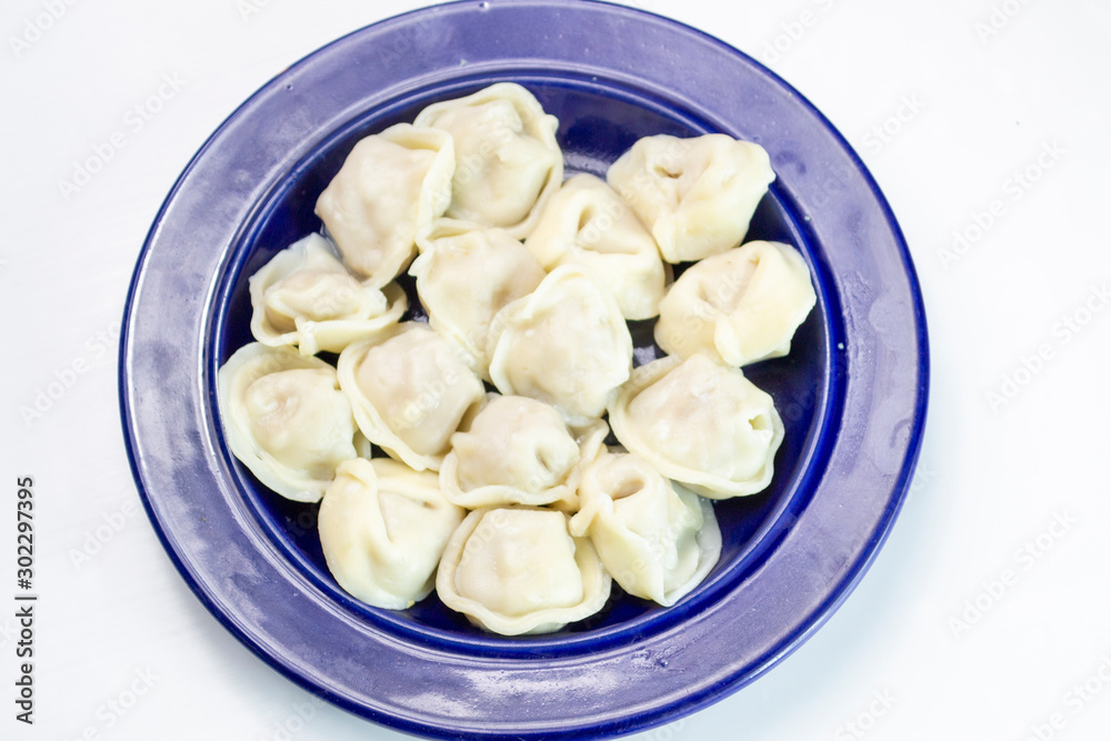 dumplings on a blue plate with sour cream